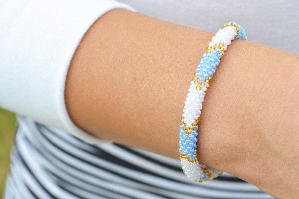 Handmade beaded friendship bracelet with blue, white, and gold glass beads. Crafted by artisans in Nepal for Sashka Co.
