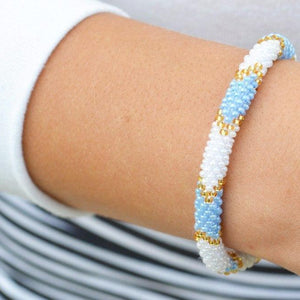 Sashka Co handmade beaded friendship bracelet with blue, white, and gold glass beads. Crafted in Nepal by skilled artisans.