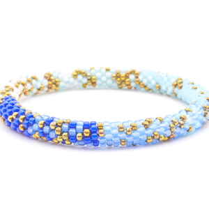 Sashka Co. handmade glass beaded friendship bracelet with iridescent bronze, blue, matte periwinkle, matte light blue, and white glass beads. Crafted in Nepal by skilled artisans.