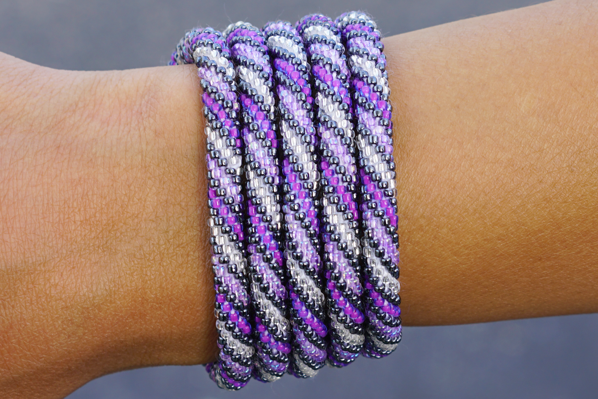 Handmade beaded friendship bracelet with purple, light purple, and silver glass beads. Crafted by artisans in Nepal for Sashka Co.