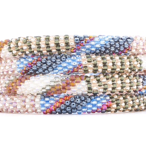 Sashka Co. handmade glass beaded friendship bracelet with silver, rose gold, blue, iridescent, and clear glass beads in a mixed pattern. Crafted in Nepal by skilled artisans.