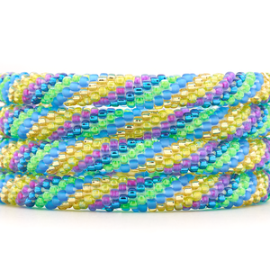 Sashka Co. handmade beaded friendship bracelet with teal, purple, gold, and green glass beads in a spiral pattern. Crafted in Nepal by skilled artisans.