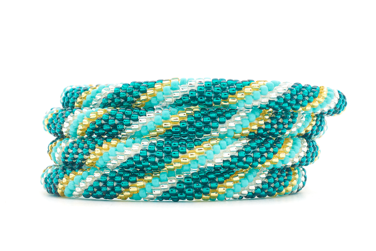 Sashka Co. handmade glass beaded friendship bracelet with teal, turquoise, champagne gold, and clear glass beads in a spiral pattern. Crafted in Nepal by skilled artisans.