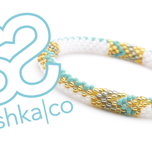 Sashka Co. handmade glass beaded friendship bracelet with turquoise, gold, white, and silver glass beads in a zipper chevron pattern. Crafted in Nepal by skilled artisans.