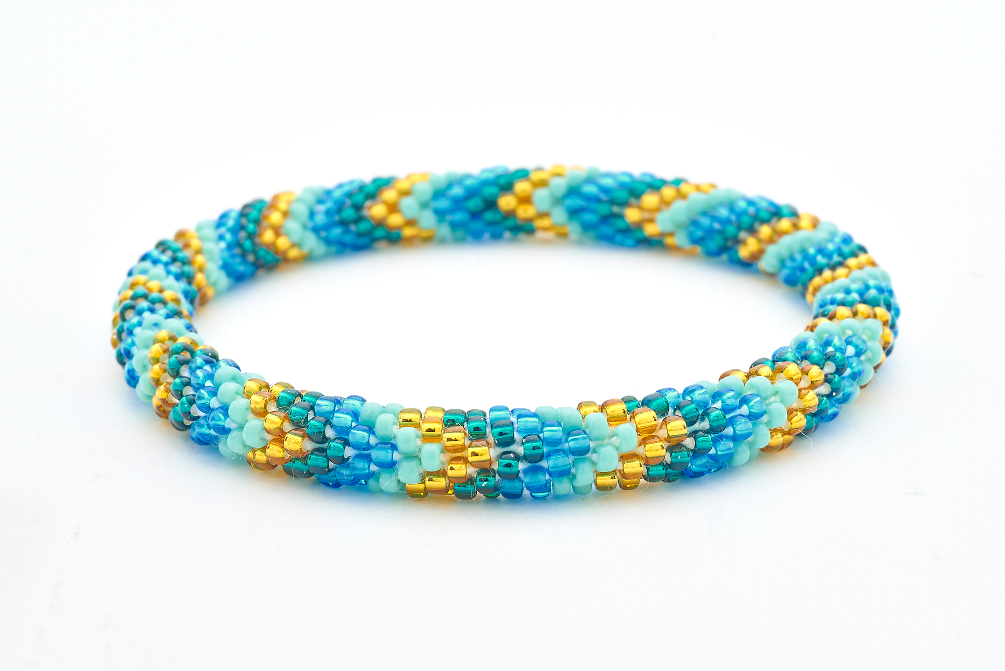 Sashka Co handmade beaded friendship bracelet with blue, gold, teal, and turquoise glass beads. Crafted in Nepal by skilled artisans in a chevron pattern.