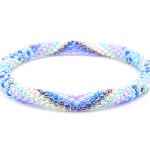 Sashka Co handmade beaded friendship bracelet with iridescent aqua, iridescent blue, purple, clear, azure blue, matte periwinkle, and iridescent glass beads. Crafted in Nepal by skilled artisans in a zigzag spiral pattern.

