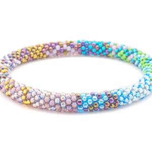 Sashka Co handmade beaded friendship bracelet with iridescent blue, green, teal, iridescent purple, mauve, gold, and gray glass beads. Crafted in Nepal by skilled artisans in a confetti pattern.