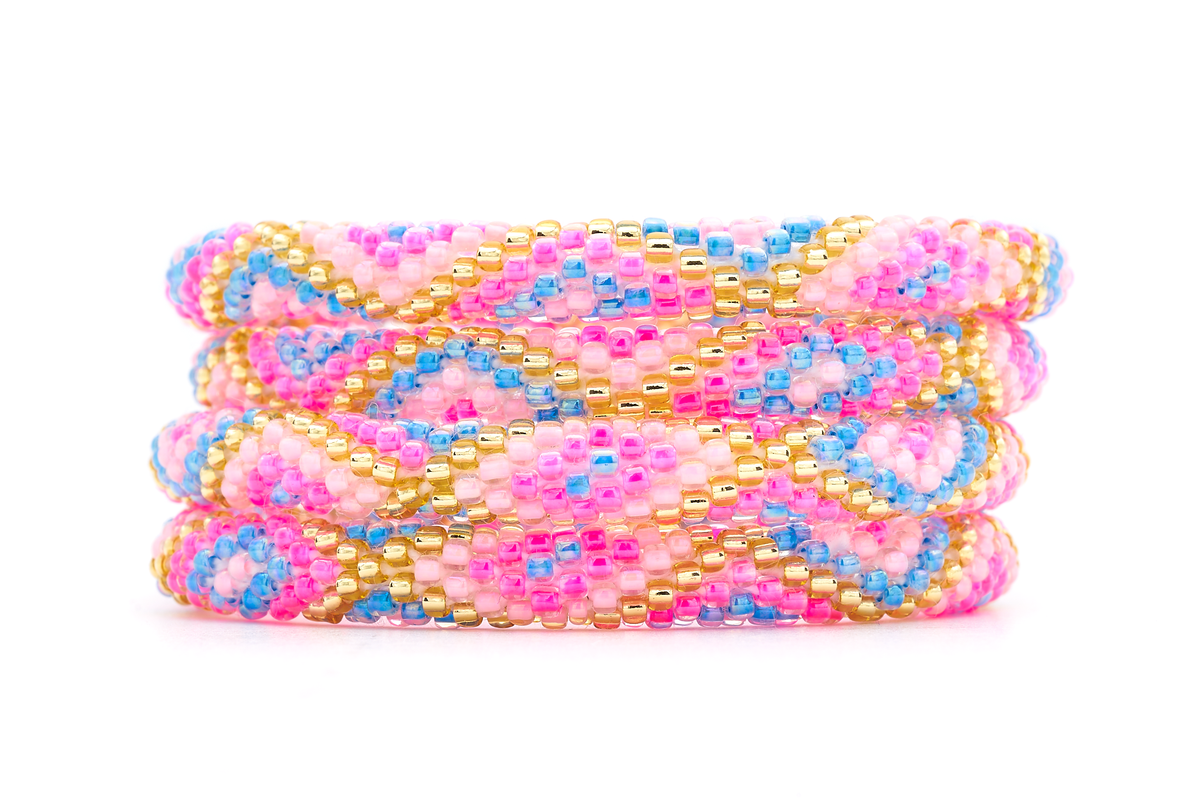 Sashka Co handmade beaded friendship bracelet with pink, light pink, blue, and champagne gold glass beads. Crafted in Nepal by skilled artisans in a criss cross pattern.