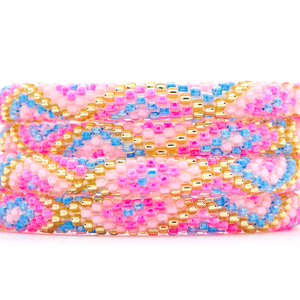 Sashka Co handmade beaded friendship bracelet with pink, light pink, blue, and champagne gold glass beads. Crafted in Nepal by skilled artisans in a criss cross pattern.