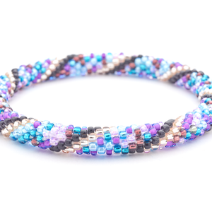 Sashka Co handmade beaded friendship bracelet with purple, black, blue, and rose gold glass beads. Crafted in Nepal by skilled artisans in a spiral mixed pattern.