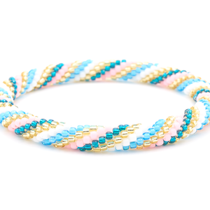 Sashka Co. handmade beaded friendship bracelet with teal, champagne gold, white, blue, and matte pink spiral pattern. Crafted in Nepal by skilled artisans.