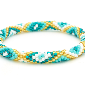 Sashka Co handmade beaded friendship bracelet with turquoise, teal, white, and champagne gold diamond pattern. Crafted in Nepal by skilled artisans.