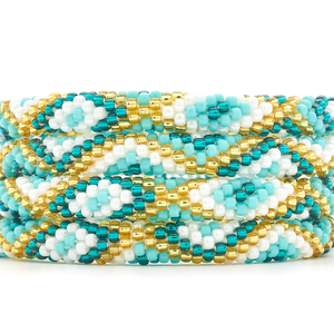 Sashka Co handmade beaded friendship bracelet with turquoise, teal, white, and champagne gold diamond pattern. Crafted in Nepal by skilled artisans.