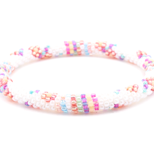 Sashka Co handmade beaded friendship bracelet with white, rose red, mint, matte purple, pink, blue, peach, and matte yellow glass beads. Crafted in Nepal by skilled artisans in a flower line pattern.

