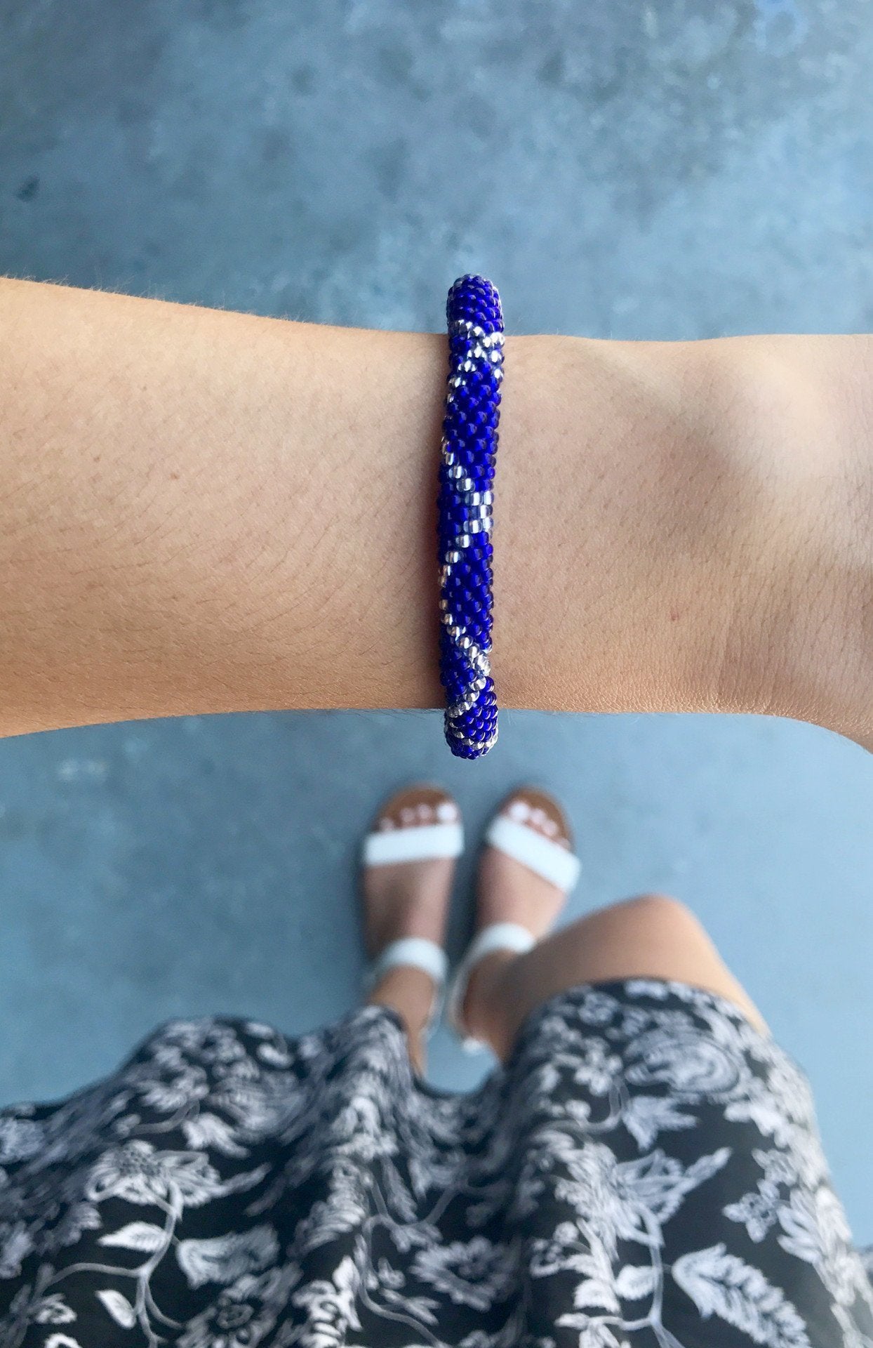 Sashka Co. handmade glass beaded friendship bracelet with blue and clear glass beads in a criss cross pattern. Crafted in Nepal by skilled artisans.