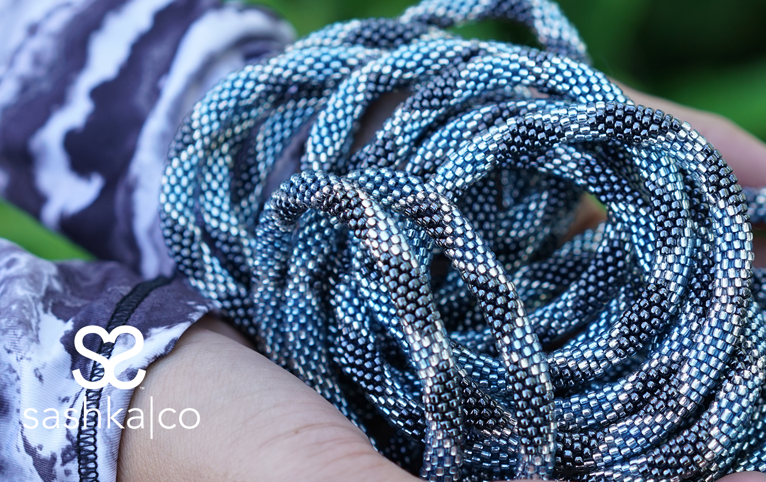 Sashka Co. handmade glass beaded friendship bracelet with blue, silver, and clear glass beads in a diamond pattern. Crafted in Nepal by skilled artisans.