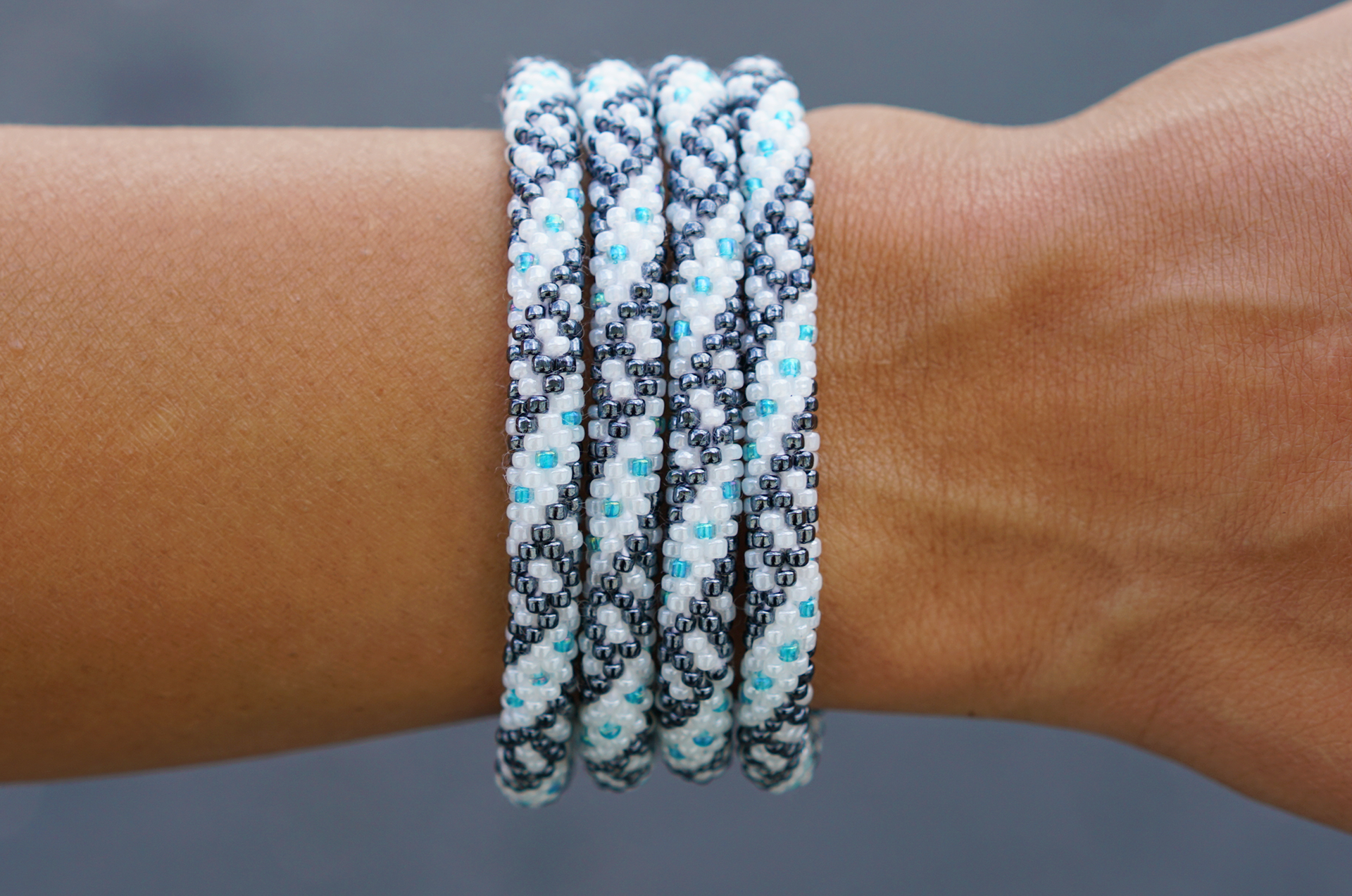 This Sashka Co. glass beaded bracelet was hand-crocheted by skilled artisans in the Kathmandu Valley of Nepal. It features a charming mix of blue, silver, and white beads in a spiral dot pattern. Sashka Co. Bracelets make amazing friendship bracelets and support fair trade, helping women in Nepal rise above poverty.