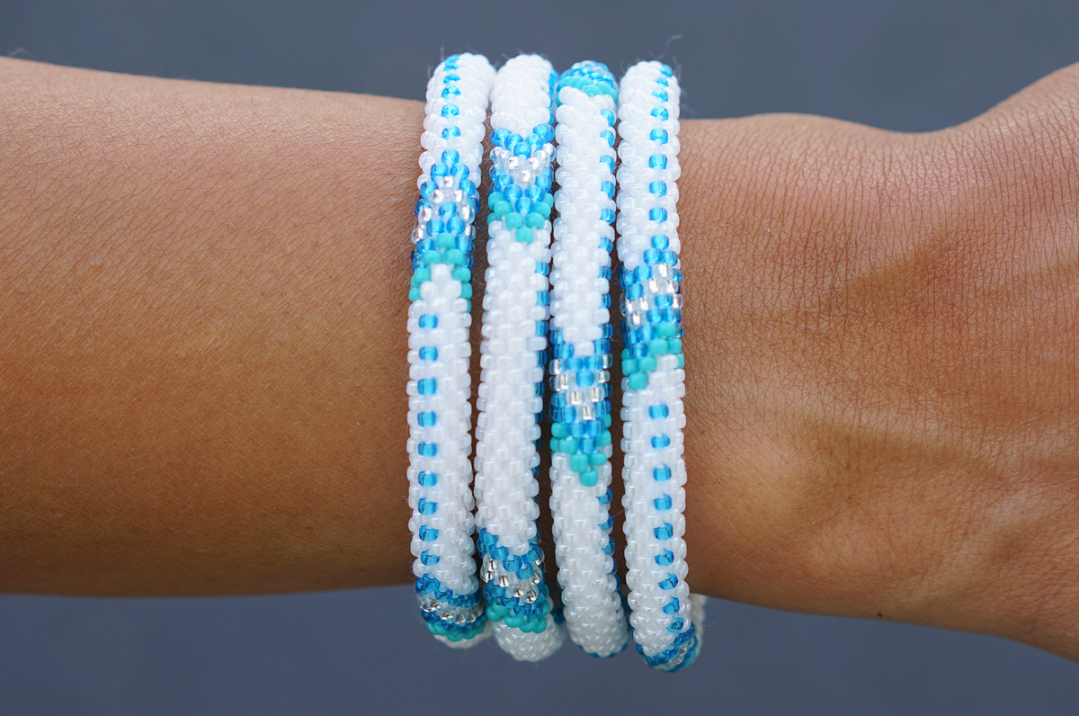Sashka Co. handmade glass beaded friendship bracelet with blue, turquoise, white, and clear glass beads in an arrow pattern. Crafted in Nepal by skilled artisans.
