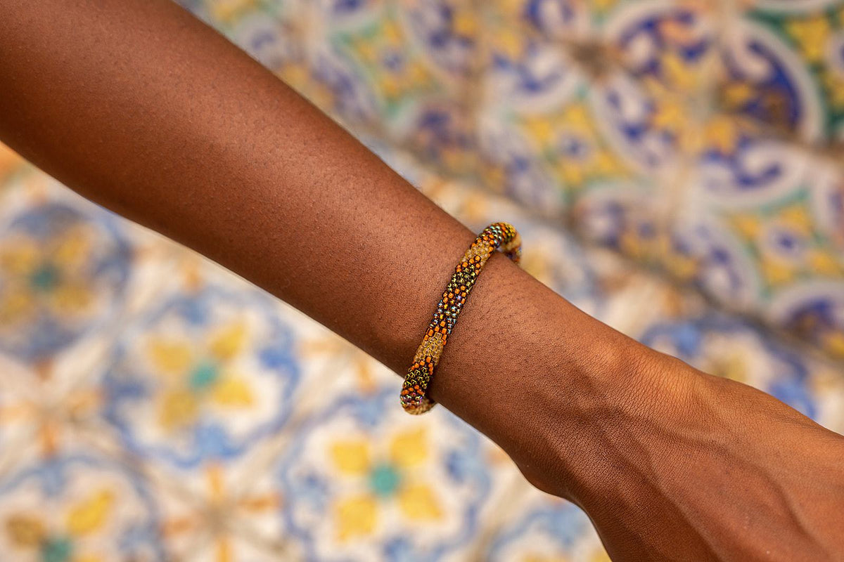 Sashka Co handmade beaded friendship bracelet with bronze, burnt orange, and mixed iridescent glass beads. Crafted in Nepal by skilled artisans.