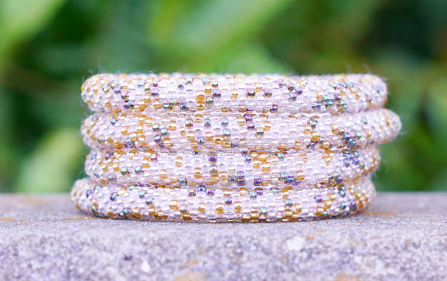 Sashka Co. handmade glass beaded friendship bracelet with clear, gold, and iridescent glass beads in a mixed pattern. Crafted in Nepal by skilled artisans.