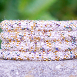 Sashka Co. handmade glass beaded friendship bracelet with clear, gold, and iridescent glass beads in a mixed pattern. Crafted in Nepal by skilled artisans.