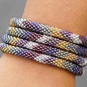 Sashka Co. handmade glass beaded friendship bracelet with gold, iridescent, silver, and plum glass beads in a chevron pattern. Crafted in Nepal by skilled artisans.