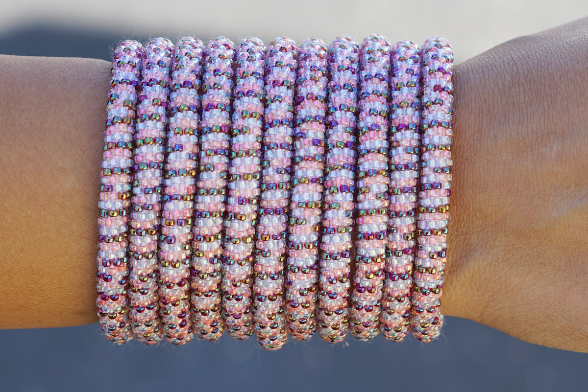 Sashka Co. handmade glass beaded friendship bracelet with iridescent clear, pink, and iridescent red glass beads in a line pattern. Crafted in Nepal by skilled artisans.