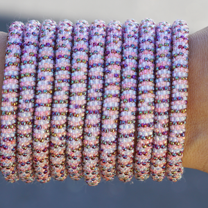 Sashka Co. handmade glass beaded friendship bracelet with iridescent clear, pink, and iridescent red glass beads in a line pattern. Crafted in Nepal by skilled artisans.