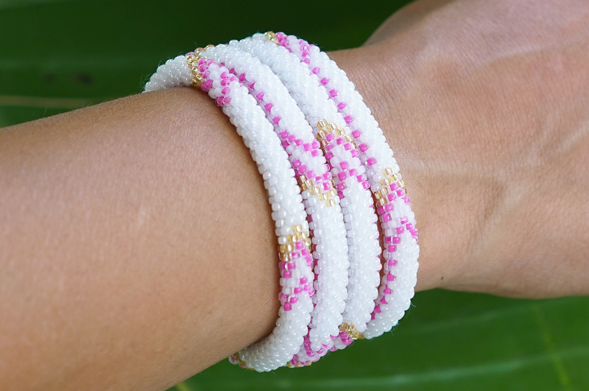 Sashka Co. handmade glass beaded friendship bracelet with pink, white, and gold glass beads in an arrow pattern. Crafted in Nepal by skilled artisans.