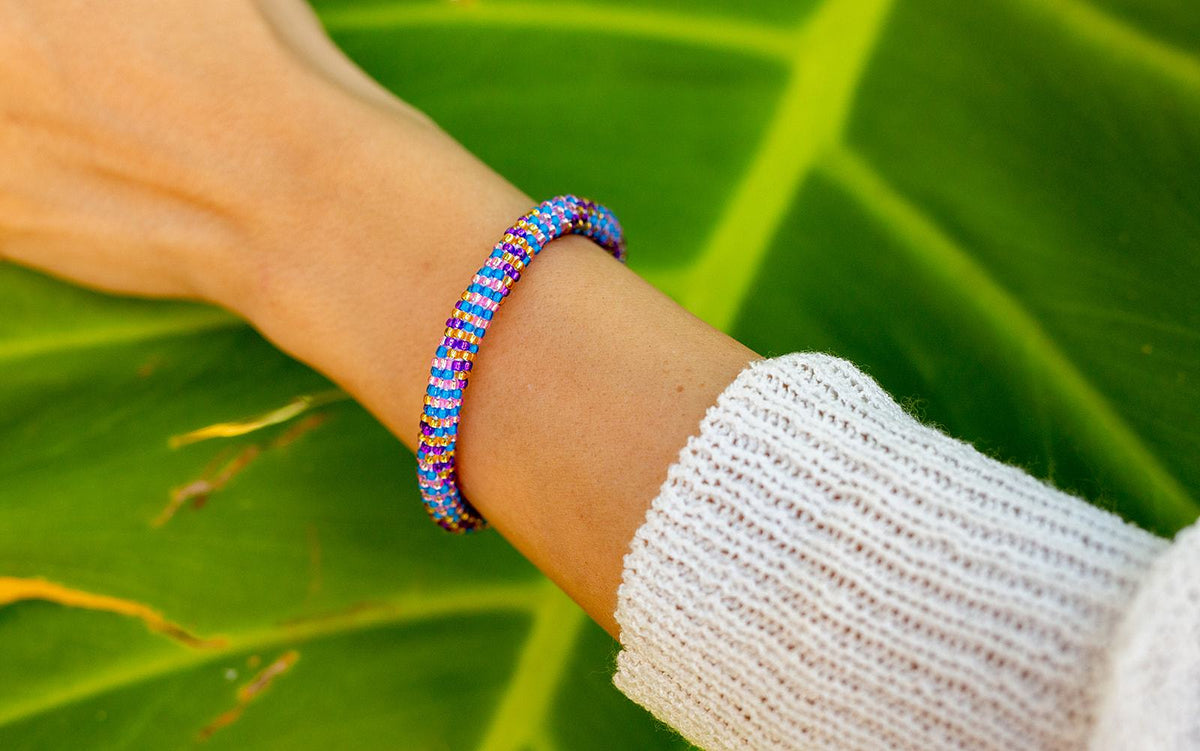 Sashka Co. handmade glass beaded friendship bracelet with rose gold, plum, clear, and black glass beads in a line 
spiral pattern. Crafted in Nepal by skilled artisans.