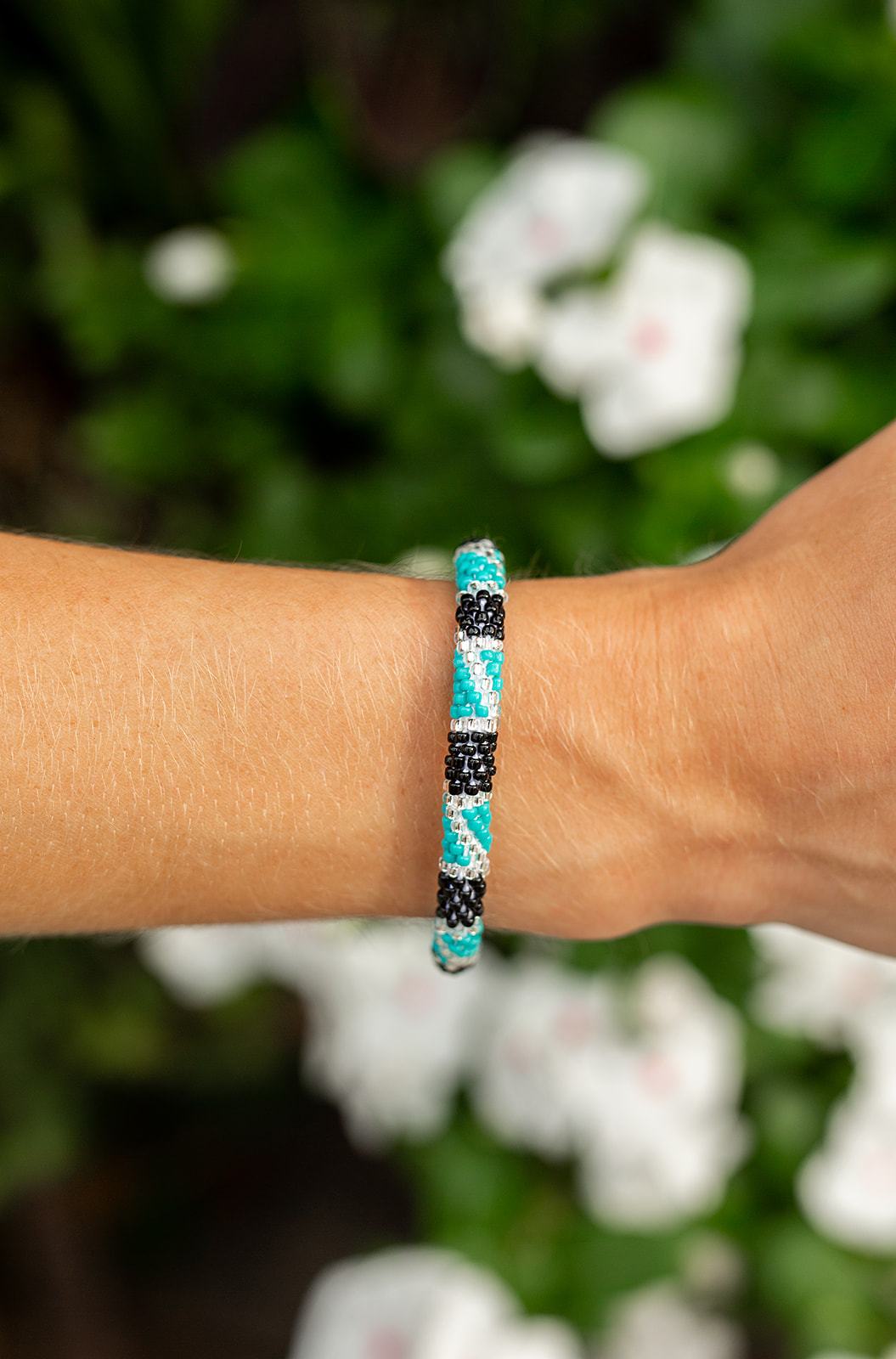 Sashka Co handmade beaded friendship bracelet with turquoise, black, and clear glass beads in a block spiral design. Crafted in Nepal by skilled artisans.