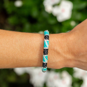 Sashka Co handmade beaded friendship bracelet with turquoise, black, and clear glass beads in a block spiral design. Crafted in Nepal by skilled artisans.