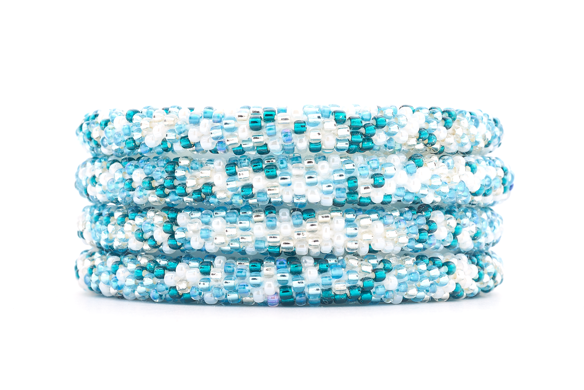 Handmade beaded friendship bracelet with white, clear, light blue, and teal glass beads. Crafted by artisans in Nepal for Sashka Co.