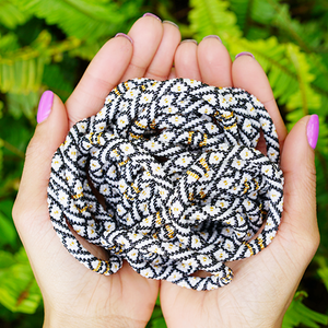 Sashka Co handmade beaded friendship bracelet with black, white, and gold glass beads. Crafted in Nepal by skilled artisans in a diamond pattern.