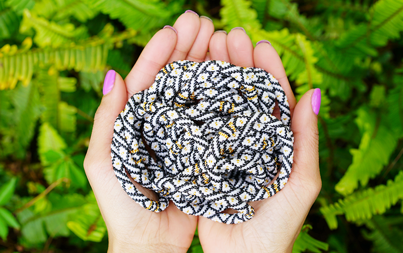 Sashka Co handmade beaded friendship bracelet with black, white, and gold glass beads. Crafted in Nepal by skilled artisans in a diamond pattern.