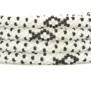 Sashka Co handmade beaded friendship bracelet with black and white glass beads. Crafted in Nepal by skilled artisans in a detailed ribbon pattern.