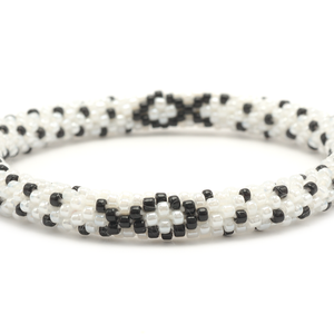 Sashka Co handmade beaded friendship bracelet with black and white glass beads. Crafted in Nepal by skilled artisans in a detailed ribbon pattern.