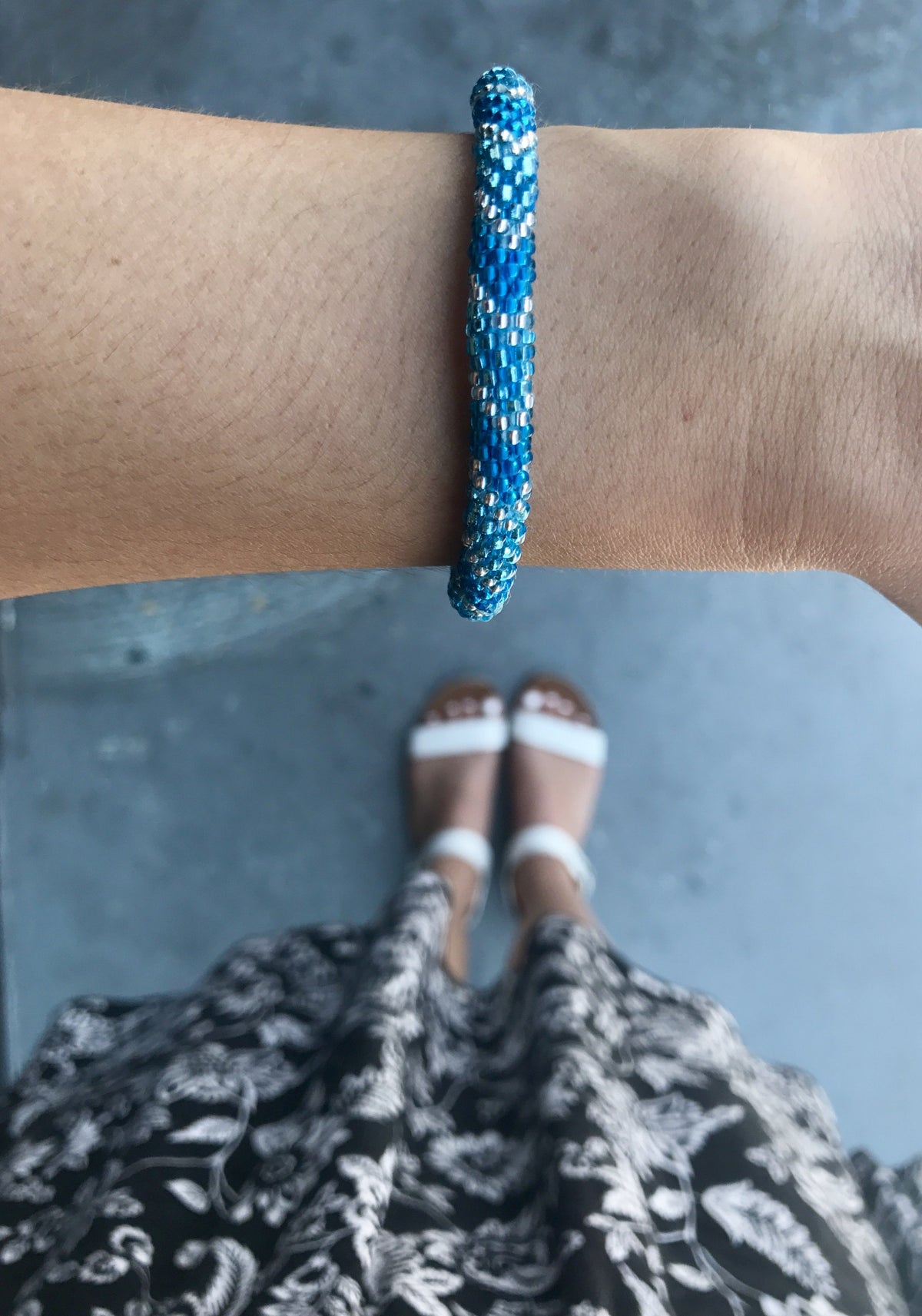 Sashka Co handmade beaded friendship bracelet with blue, metallic blue, and clear glass beads. Crafted in Nepal by skilled artisans in a chevron pattern.
