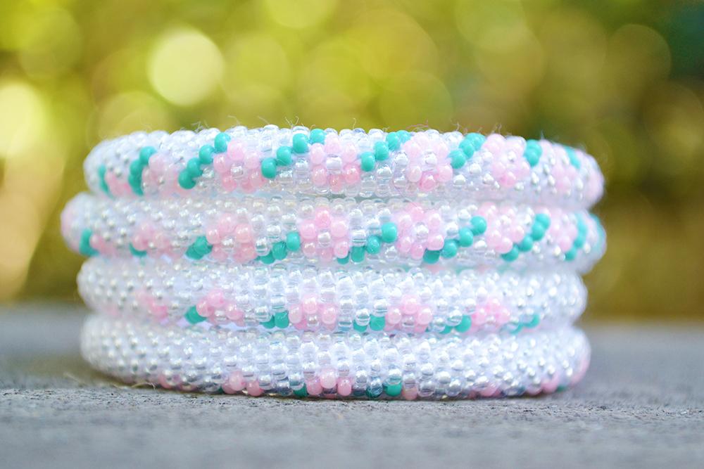 Sashka Co handmade beaded friendship bracelet with clear, pink, and turquoise glass beads. Crafted in Nepal by skilled artisans in a detailed flower pattern.