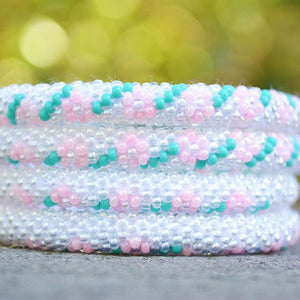 Sashka Co handmade beaded friendship bracelet with clear, pink, and turquoise glass beads. Crafted in Nepal by skilled artisans in a detailed flower pattern.