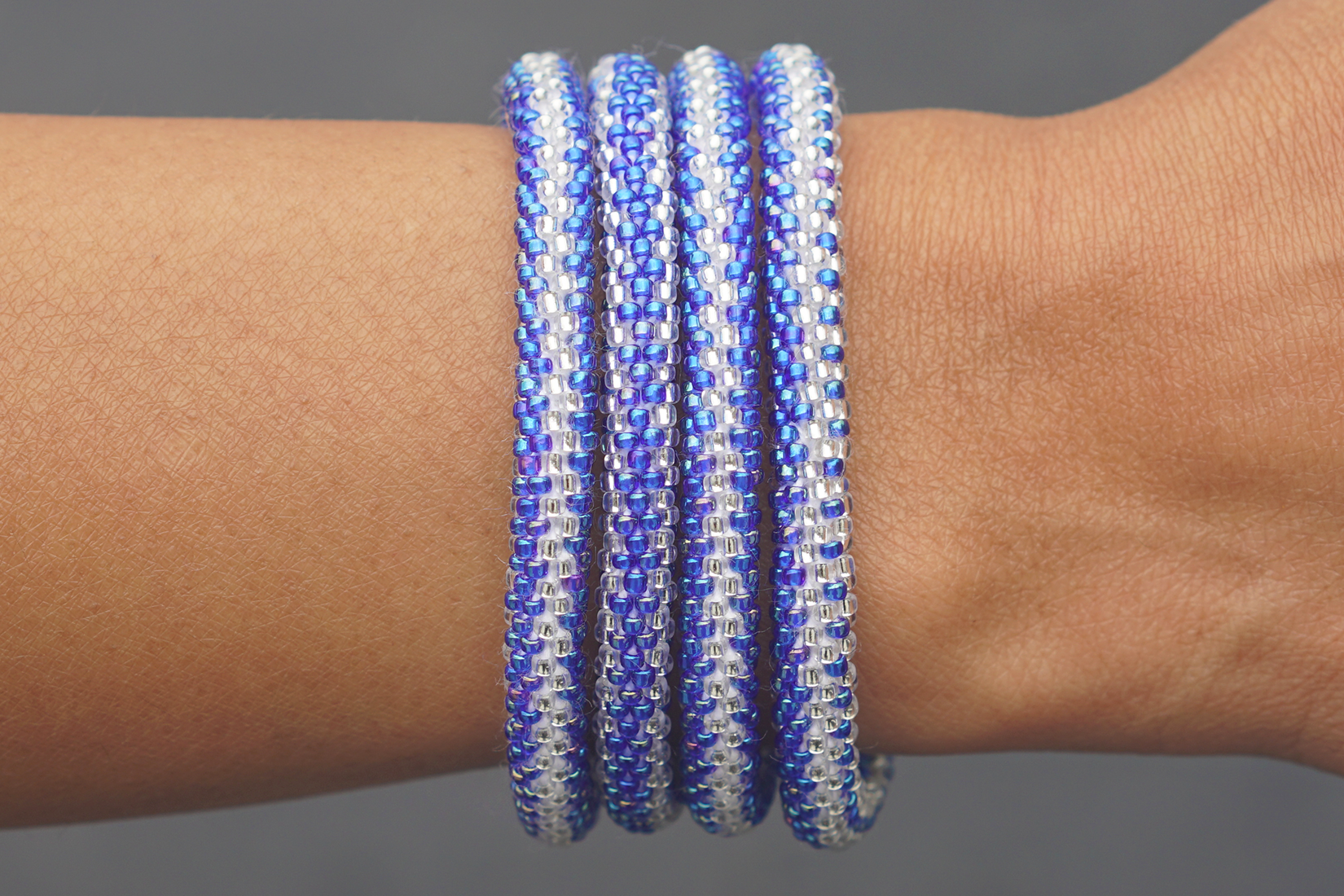 Sashka Co handmade beaded friendship bracelet with iridescent blue and clear glass beads. Crafted in Nepal by skilled artisans in a zipper pattern.