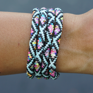 Sashka Co handmade beaded friendship bracelet with mint, black, and confetti glass beads. Crafted in Nepal by skilled artisans in a detailed diamond pattern.