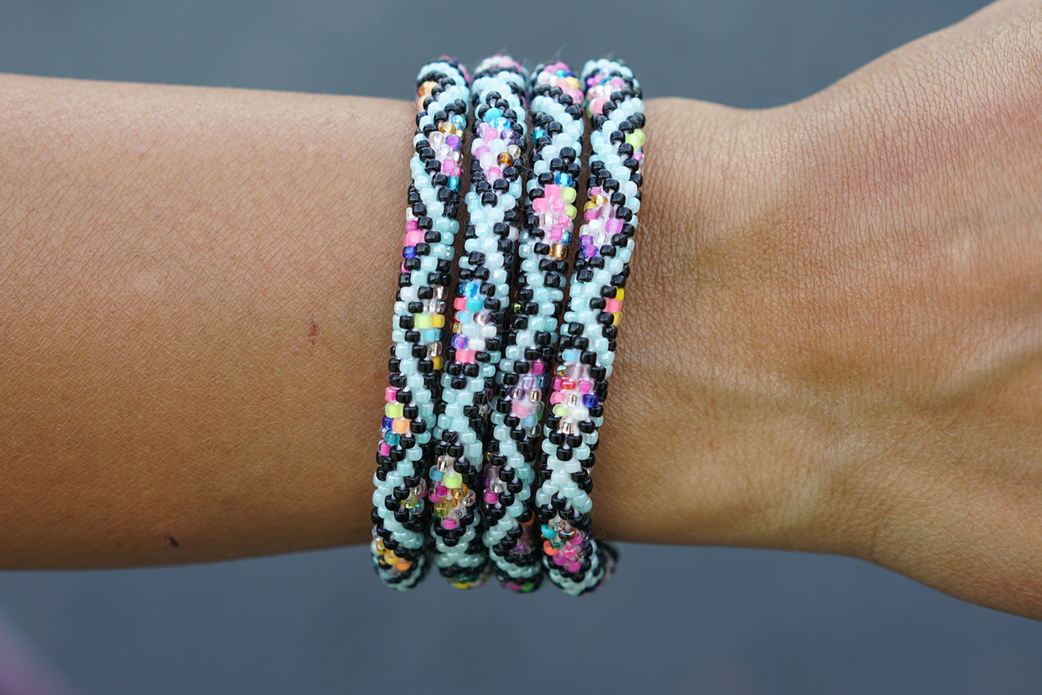 Sashka Co handmade beaded friendship bracelet with mint, black, and confetti glass beads. Crafted in Nepal by skilled artisans in a detailed diamond pattern.