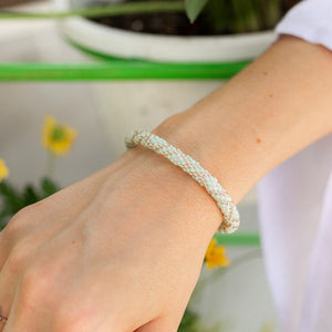 Sashka Co handmade beaded friendship bracelet with mint, rose gold, and pink criss cross pattern. Crafted in Nepal by skilled artisans.