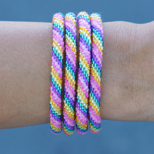 Sashka Co handmade beaded friendship bracelet with pink, purple, teal, yellow, and orange spiral pattern. Crafted in Nepal by skilled artisans.