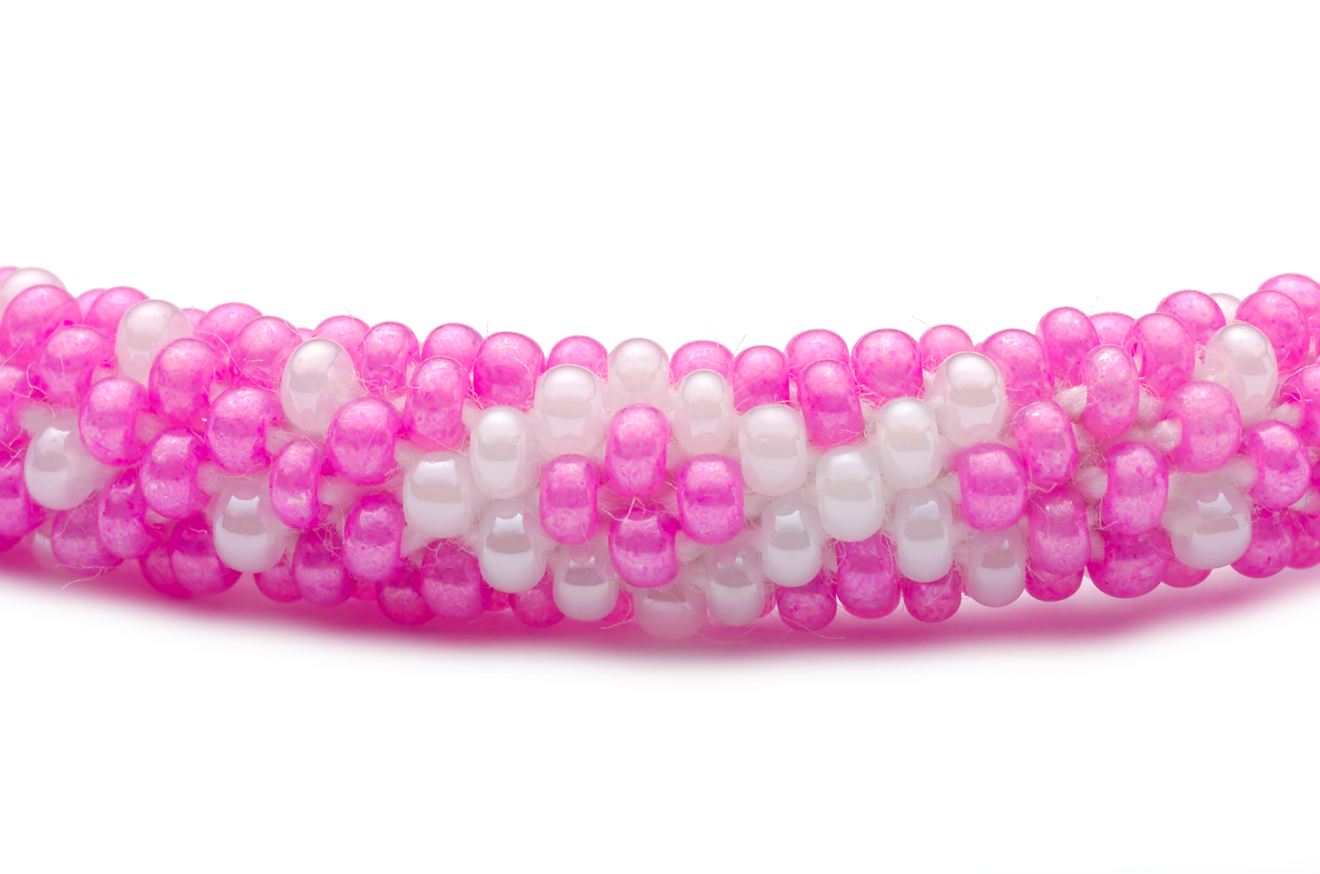 Sashka Co handmade beaded friendship bracelet with pink and white glass beads. Crafted in Nepal by skilled artisans in a detailed ribbon pattern.