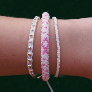 Sashka Co handmade beaded friendship bracelet with pink and white glass beads. Crafted in Nepal by skilled artisans in a detailed ribbon pattern.