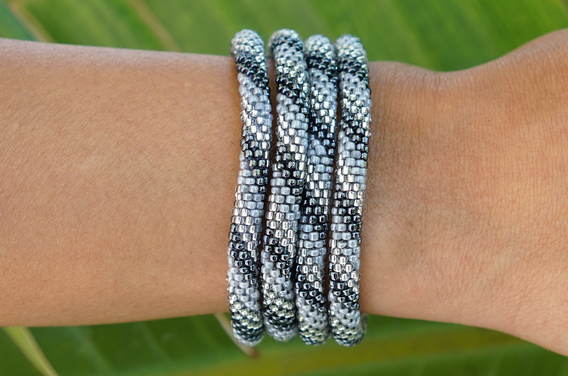 Sashka Co handmade beaded friendship bracelet with silver, gray, and clear glass beads. Crafted in Nepal by skilled artisans in a spiral pattern.