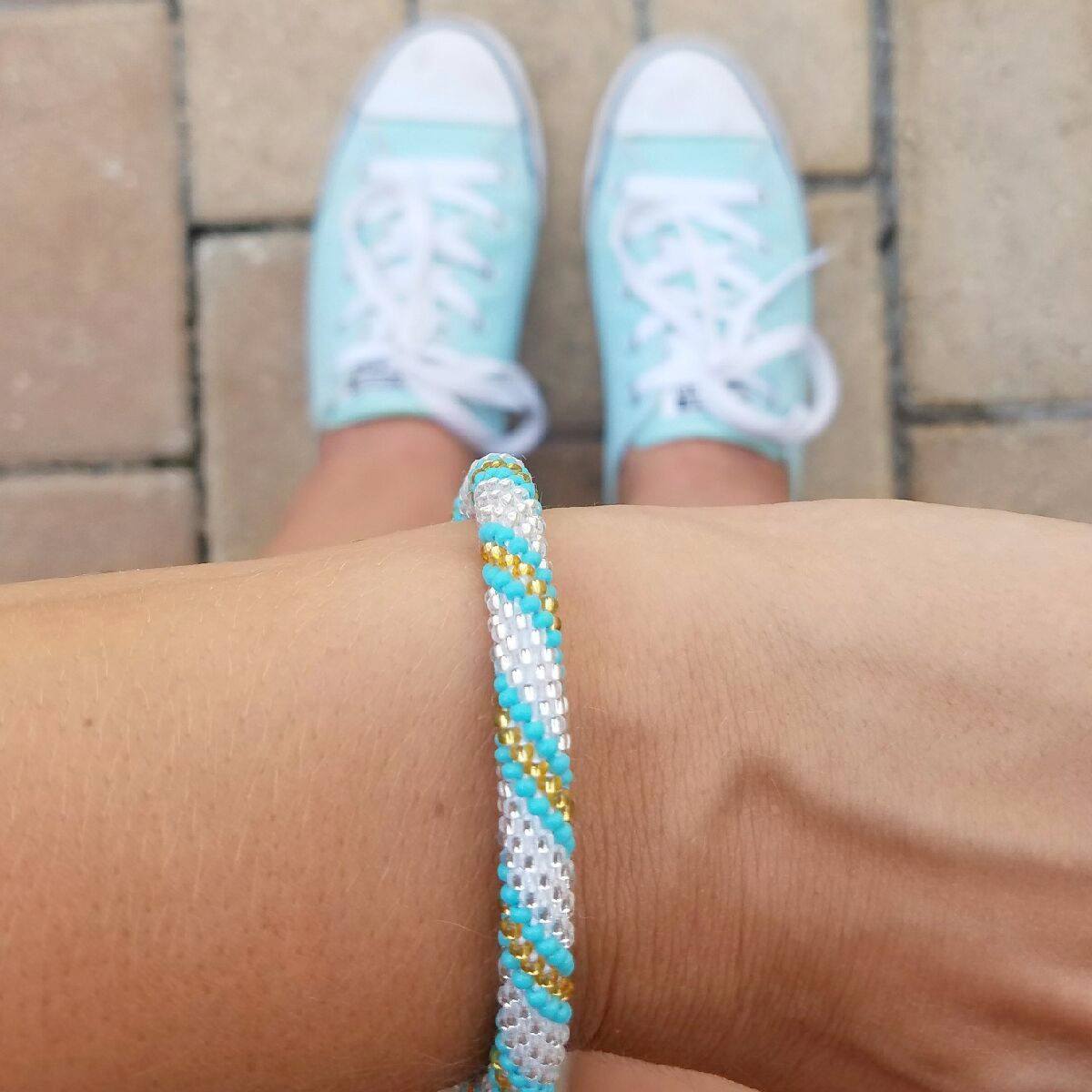 Sashka Co handmade beaded friendship bracelet with turquoise, clear, and champagne gold glass beads. Crafted in Nepal by skilled artisans in a spiral pattern.