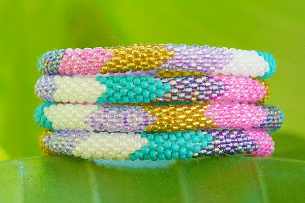 Sashka Co handmade beaded friendship bracelet with turquoise, gold, pink, purple, and white glass beads. Crafted in Nepal by skilled artisans.